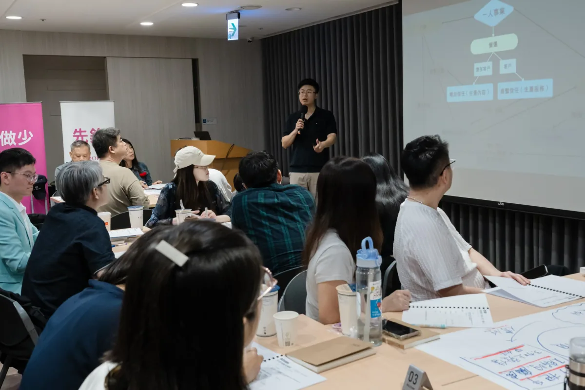 Chris 穿黑色上衣，在黑棕高峰會分享事業系統與發售方法