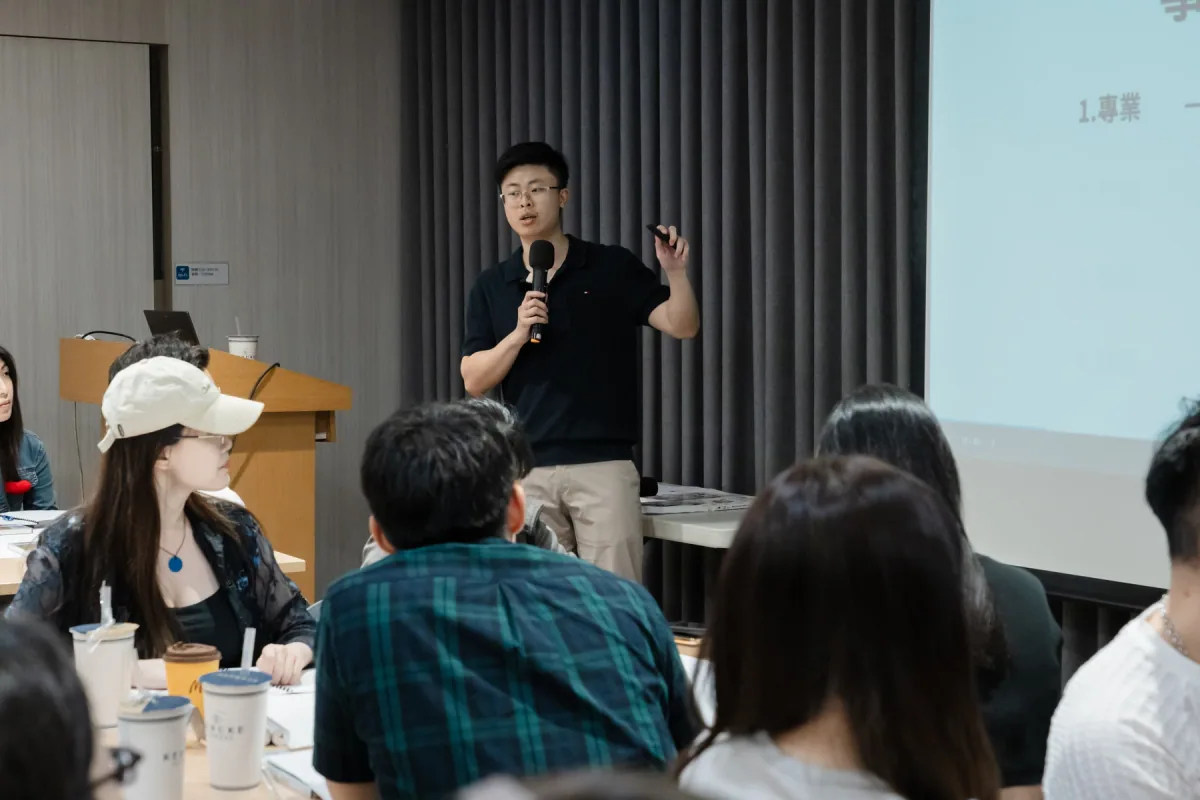 Chris 在黑棕高峰會持麥克風授課